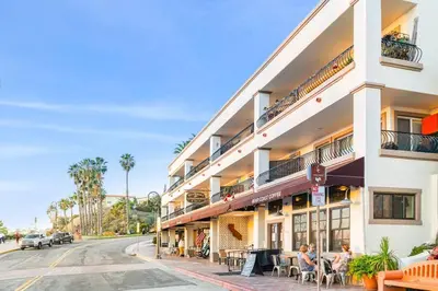 a building on a street with people sitting outside of it at Blue Whale Inn San Clemente Jewel Unit D in San Clemente