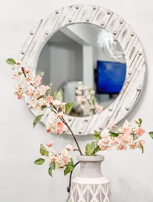 a vase with flowers in front of a mirror at Gaslamp 2BR Suite Free Parking Convention Walk in San Diego