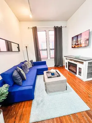 a living room with a blue couch and a tv at 2BR Downtown Suite Free Parking - Conv Center in San Diego