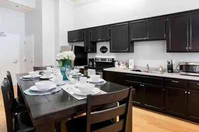 a kitchen with black cabinets and a table with chairs at 2BR Downtown Suite Free Parking - Conv Center in San Diego