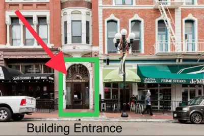 a building entrance on a city street with a red arrow at Top Floor Conv Center Free Parking 4 Beds in San Diego