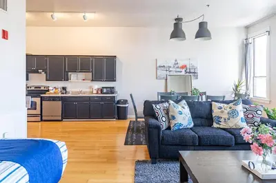 a living room with a blue couch and a kitchen at Top Floor Conv Center Free Parking 4 Beds in San Diego