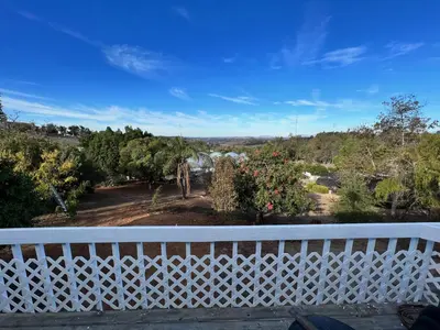 a balcony with a white fence and a view of a yard at House on Organic Farm in Escondido