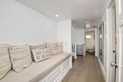 a white room with a bench with a pillow at Luxury Ocean Views & Steps To The Sand - Tower 36 Lower Condo Unit in Carlsbad