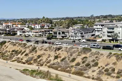 a city with cars parked on a road and houses at Luxury Ocean Views & Steps To The Sand - Tower 36 Upper Condo Unit in Carlsbad