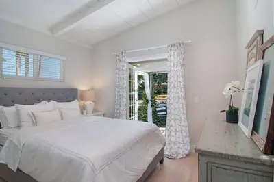 a white bedroom with a large bed and a window at Walk to Beach, AC, Firepit, Grill in Carlsbad