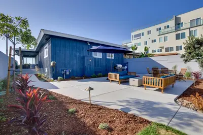 a patio with two benches and a blue building at Oceanfront Escape Steps to Imperial Beach! in Imperial Beach