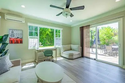 a living room with a ceiling fan and a chair at @ Marbella Lane - Modern and Sophisticated Home in Irvine