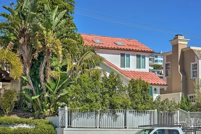 a house with a white fence and palm trees at Luxe Laguna Home with Ocean View Walk to Beach in Laguna Beach