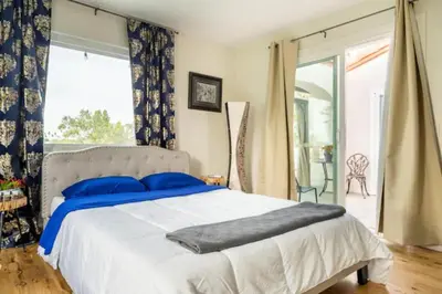 a bedroom with a large bed with blue pillows at MAGIC VILLA Overlooking Pool Oasis in Temecula