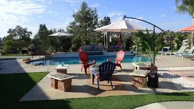 a pool with chairs and a table and an umbrella at MAGIC VILLA Overlooking Pool Oasis in Temecula