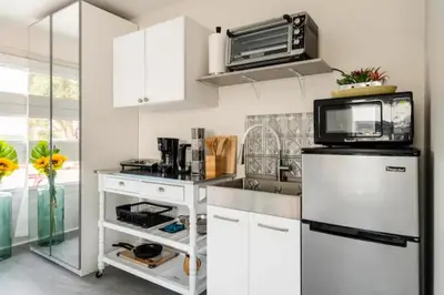 a kitchen with white cabinets and a microwave at MAGIC VILLA Overlooking Pool Oasis in Temecula