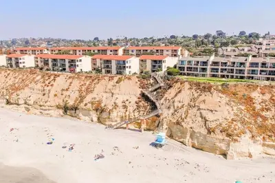 a group of buildings on top of a cliff next to a beach at Oceanfront Views, Heated Pool, Hot Tubs, Parking in Solana Beach