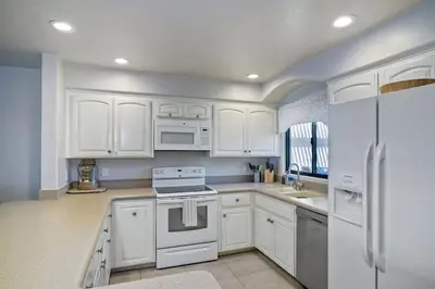 a white kitchen with white cabinets and white appliances at Oceanfront Views, Heated Pool, Hot Tubs, Parking in Solana Beach