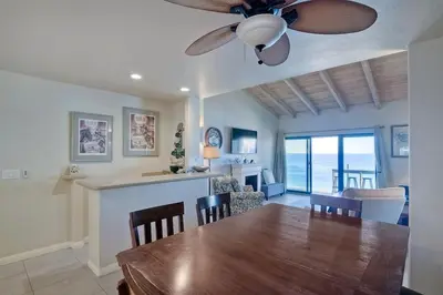 a dining room and living room with a ceiling fan at Oceanfront Views, Heated Pool, Hot Tubs, Parking in Solana Beach