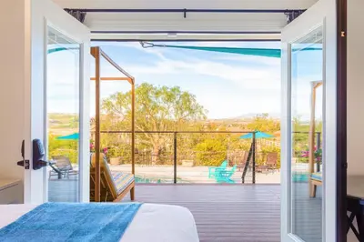 a bedroom with a bed and a view of a deck at Villa Inn- Adult Only- Temecula Wine Country in Temecula