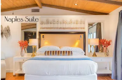a bedroom with a large white bed with a wooden headboard at Villa Inn- Adult Only- Temecula Wine Country in Temecula