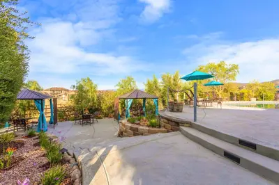 a patio with tables and umbrellas in a park at Villa Inn- Adult Only- Temecula Wine Country in Temecula
