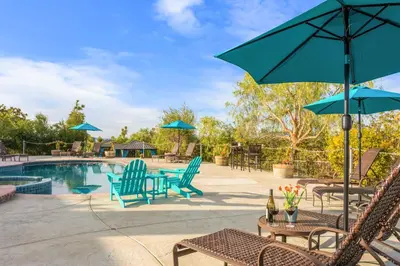 a patio with chairs and umbrellas and a pool at Villa Inn- Adult Only- Temecula Wine Country in Temecula