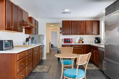 a kitchen with wooden cabinets and a table and chairs at Borrego Springs Retreat with Pool and Mtn Views in Borrego Springs