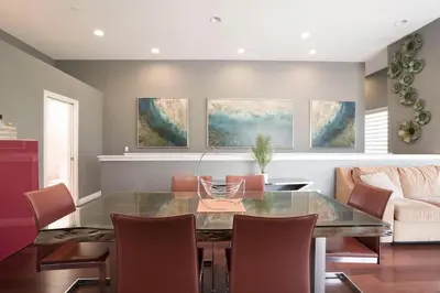 a dining room with a glass table and chairs at Architectural Gem La Jolla Oceanview surf and golf in San Diego