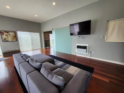 a living room with a couch and a flat screen tv at Architectural Gem La Jolla Oceanview surf and golf in San Diego