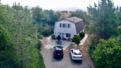 two cars parked in front of a white house at Wondrous Stays in Temecula