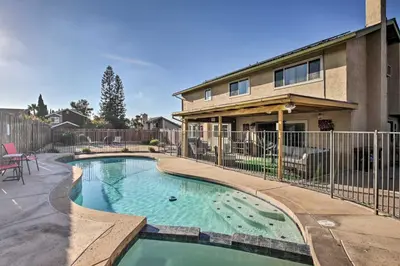 a swimming pool in front of a house at Breeze By the Pool Chula Vista Home with Game Room in Chula Vista
