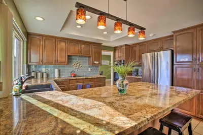 a kitchen with wooden cabinets and a granite counter top at Breeze By the Pool Chula Vista Home with Game Room in Chula Vista