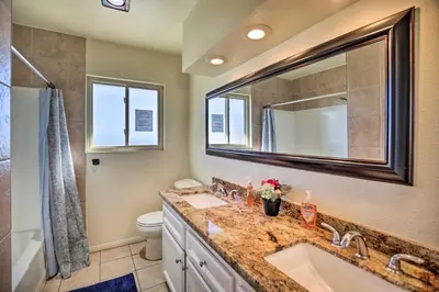 a bathroom with a sink and a toilet and a mirror at Breeze By the Pool Chula Vista Home with Game Room in Chula Vista