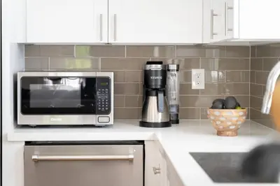 a kitchen counter with a microwave and a bowl of fruit at Fabulous New 4BR/3BA House in Mission Hills in San Diego