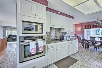 a kitchen with white cabinets and a dining room at Escondido Hilltop Home with Deck and Views! in Escondido