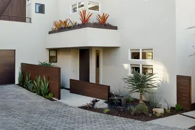 a white house with plants on the side of it at Grandview Getaway, Luxury 4BR, Ocean View, Fire Pit in Encinitas