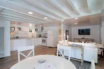 a large kitchen and living room with white furniture at Remodeled Beach Bungalow, Block to the Beach in Carlsbad
