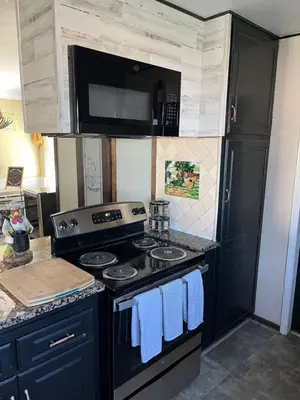 a kitchen with a black stove and a microwave at Peaceful & Cozy 3 bedroom Ranch-Home w/Fireplace in Hemet