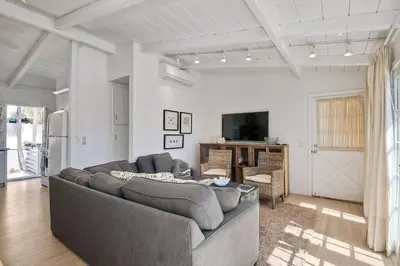 a living room with a gray couch and a tv at Walk to Beach, Patio with Ocean View, AC in Carlsbad