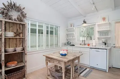 a kitchen with white cabinets and a wooden table at Walk to Beach, Patio with Ocean View, AC in Carlsbad