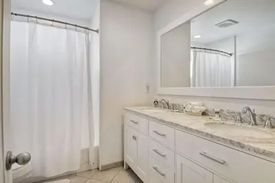 a white bathroom with a sink and a mirror at Walk to Beach, Patio with Ocean View, AC in Carlsbad