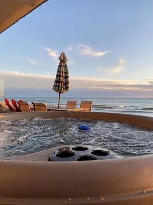 a hot tub on the beach with chairs and an umbrella at ON THE SAND!! Private Beach! OCEAN FRONT HOT TUB!! in Dana Point