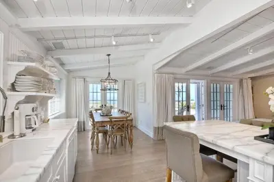 a white kitchen with a table and a dining room at Ocean Views, Across The Street From Beach, Private Patio in Carlsbad