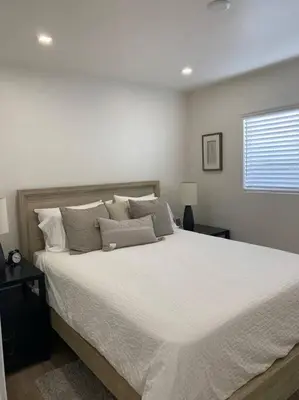 a bedroom with a large bed with white sheets and pillows at Amazing New & Water Vu/Balboa Peninsula! EV charge in Newport Beach