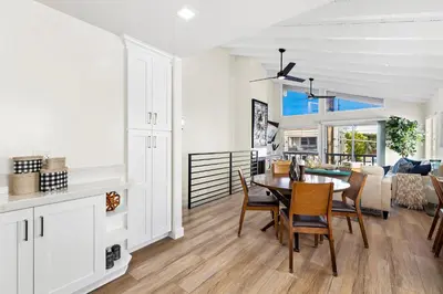 a kitchen and living room with a table and chairs at Amazing New & Water Vu/Balboa Peninsula! EV charge in Newport Beach