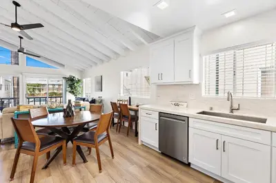 a kitchen and dining room with a table and chairs at Amazing New & Water Vu/Balboa Peninsula! EV charge in Newport Beach