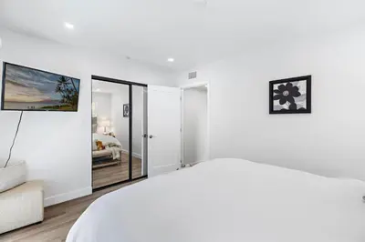 a white bedroom with a bed and a couch at Amazing New & Water Vu/Balboa Peninsula! EV charge in Newport Beach