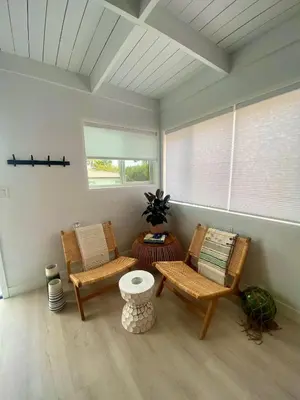 a room with two chairs and a table and windows at Village District! Cleo Beach! 5 Min Walk to DTWN! in Laguna Beach