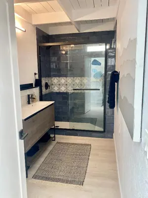 a bathroom with a shower and a sink with a glass door at Village District! Cleo Beach! 5 Min Walk to DTWN! in Laguna Beach