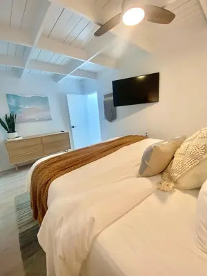a bedroom with two beds and a flat screen tv at Village District! Cleo Beach! 5 Min Walk to DTWN! in Laguna Beach