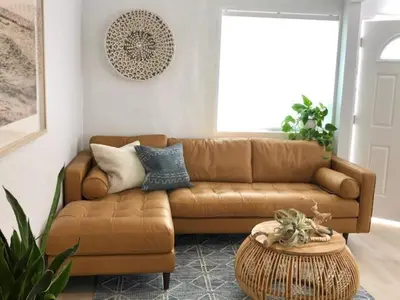 a living room with a brown couch and a table at Village District! Cleo Beach! 5 Min Walk to DTWN! in Laguna Beach