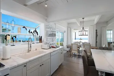 a kitchen with a sink and a dining room at Expansive Ocean View, Private Balcony, Across from Beach in Carlsbad