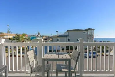 a table and chairs on a balcony overlooking the ocean at Ocean View From Private Patio, Across Street From Beach in Carlsbad